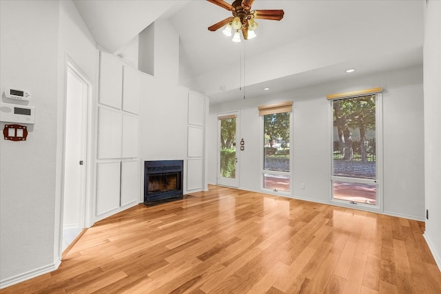 unfurnished living room featuring light hardwood / wood-style flooring, high vaulted ceiling, and ceiling fan