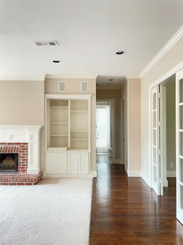 unfurnished living room featuring crown molding, a brick fireplace, and dark hardwood / wood-style floors