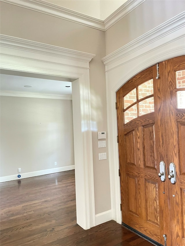 foyer with ornamental molding and dark wood-type flooring