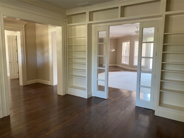 interior space featuring french doors, dark wood-type flooring, crown molding, built in shelves, and ceiling fan