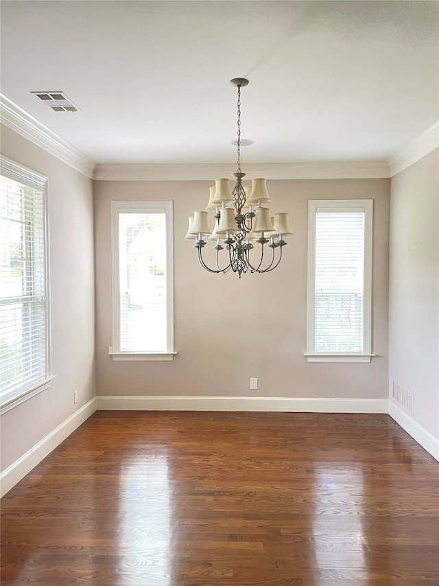 empty room featuring crown molding, a chandelier, and dark hardwood / wood-style flooring