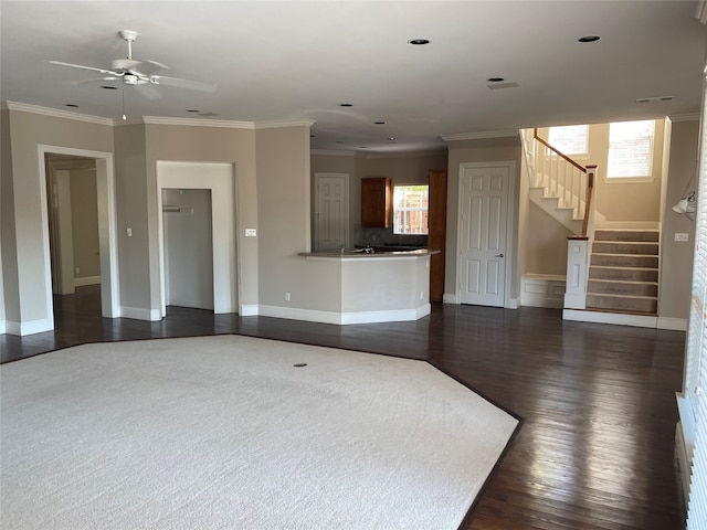 unfurnished living room with dark wood-type flooring, crown molding, and ceiling fan