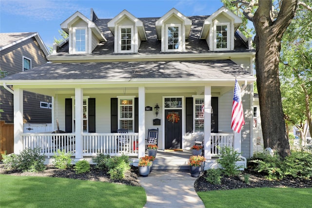 cape cod home with a porch and a front yard