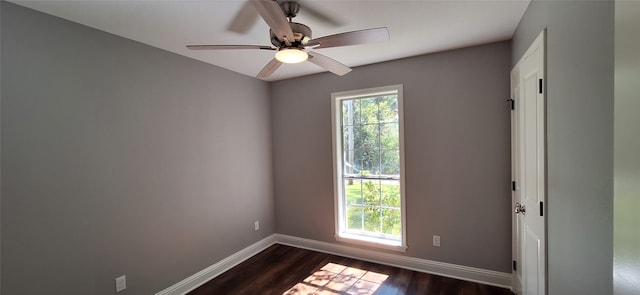 spare room featuring dark wood-type flooring and ceiling fan