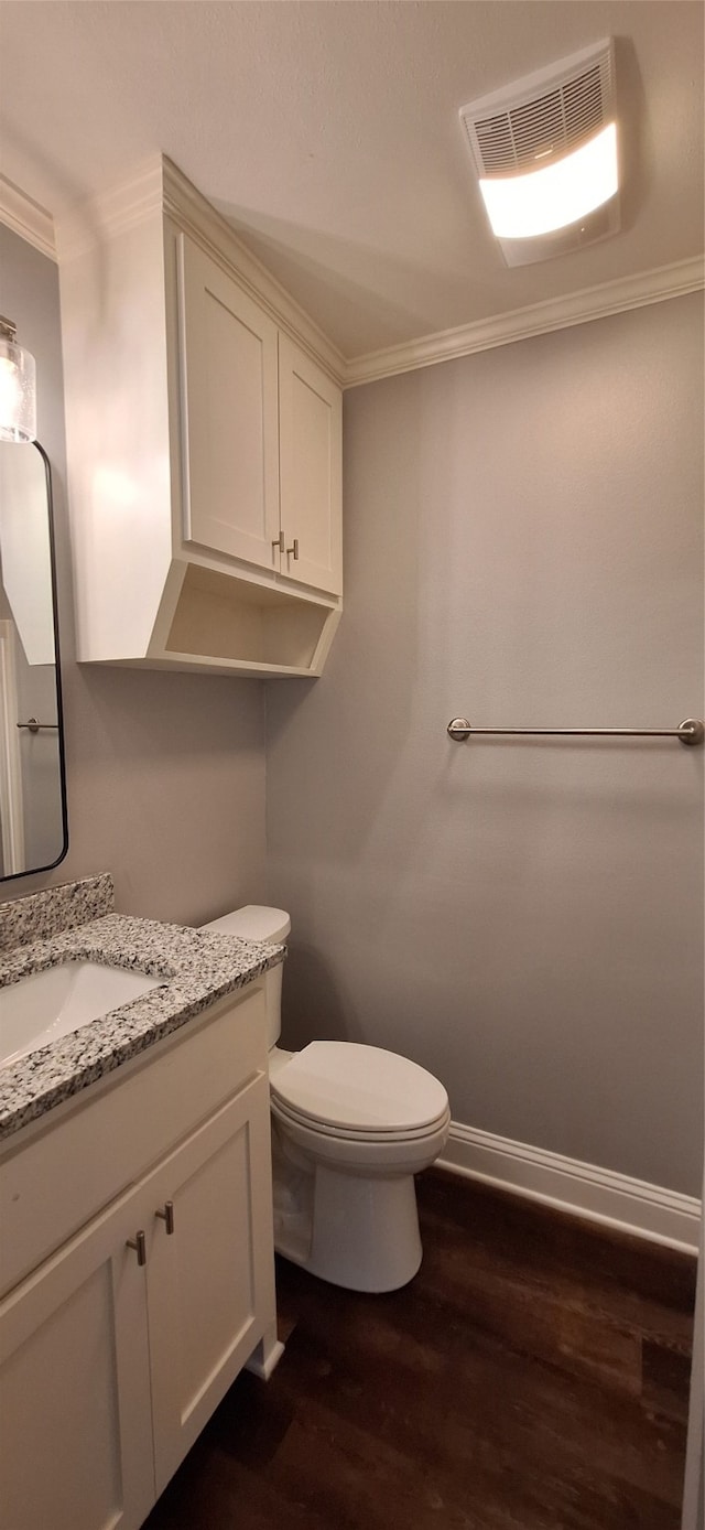 bathroom featuring vanity, ornamental molding, hardwood / wood-style flooring, and toilet