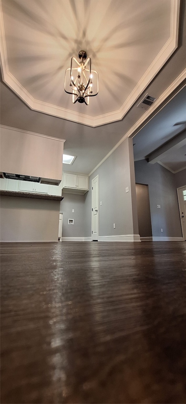 unfurnished living room with crown molding, a notable chandelier, and dark hardwood / wood-style floors