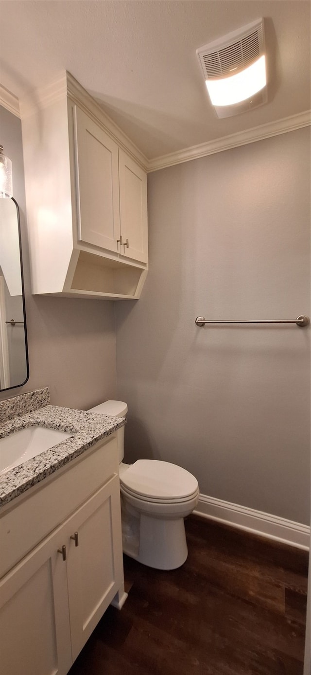 bathroom with vanity, hardwood / wood-style floors, crown molding, and toilet