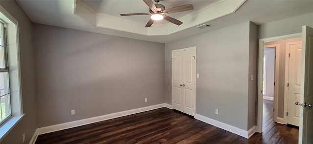 spare room with crown molding, a raised ceiling, ceiling fan, and dark hardwood / wood-style flooring