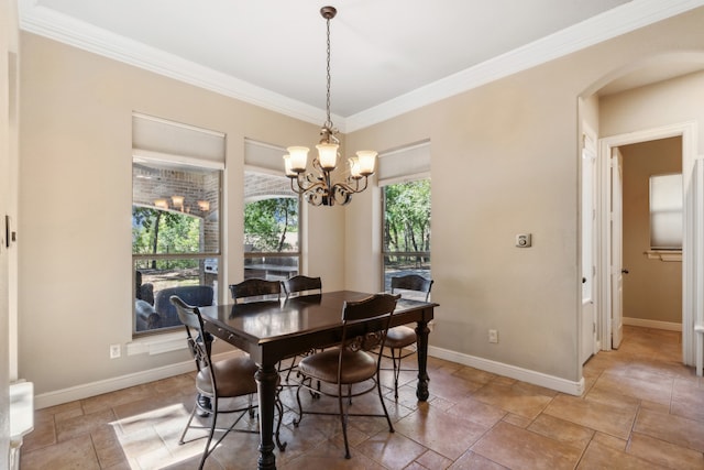 dining area featuring ornamental molding and an inviting chandelier