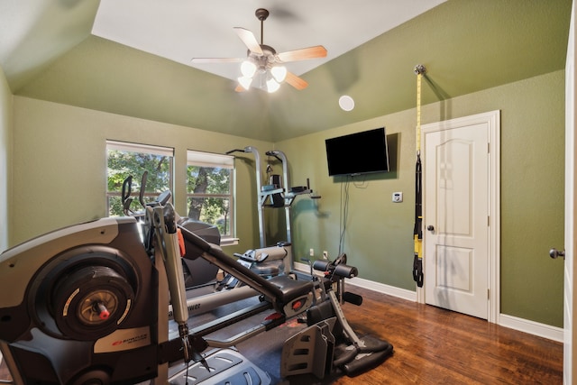 workout room with ceiling fan, vaulted ceiling, and dark hardwood / wood-style flooring