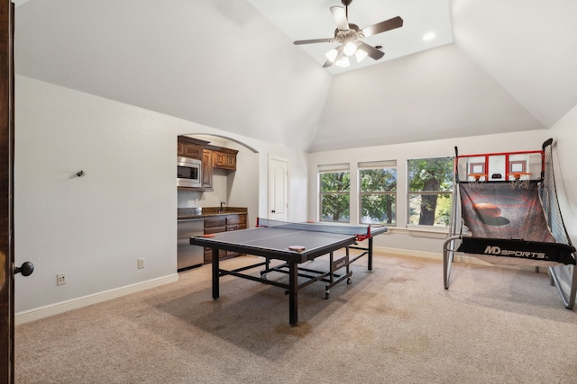 rec room featuring vaulted ceiling, light colored carpet, and ceiling fan