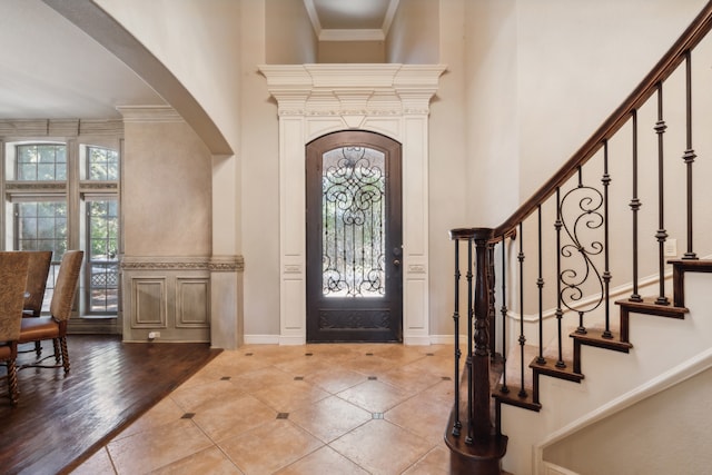 foyer featuring ornamental molding, hardwood / wood-style floors, and a high ceiling