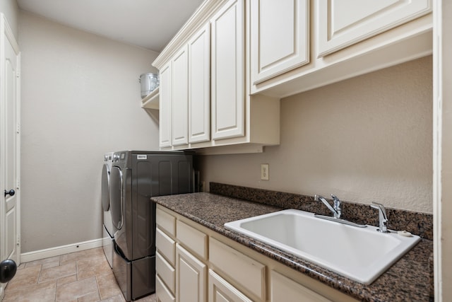 clothes washing area with cabinets, sink, and washing machine and dryer