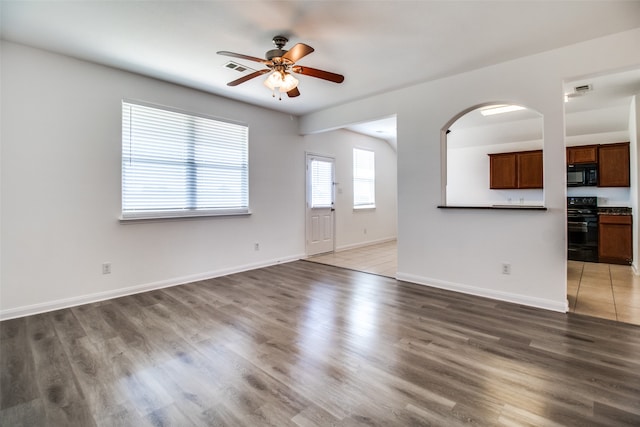 unfurnished living room with ceiling fan and hardwood / wood-style floors