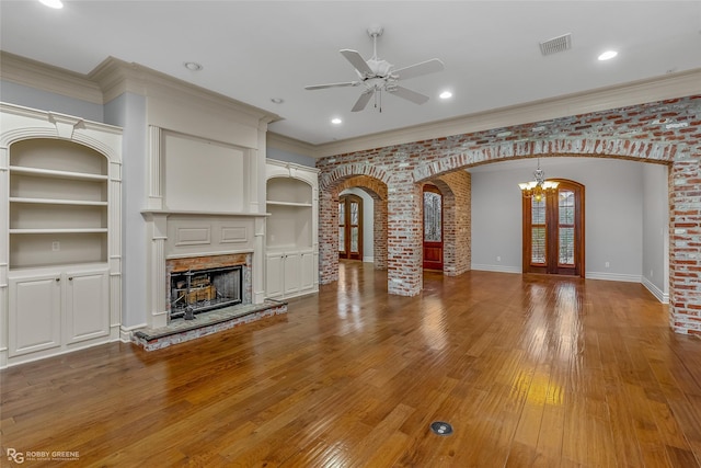 unfurnished living room with ornamental molding, brick wall, and hardwood / wood-style floors