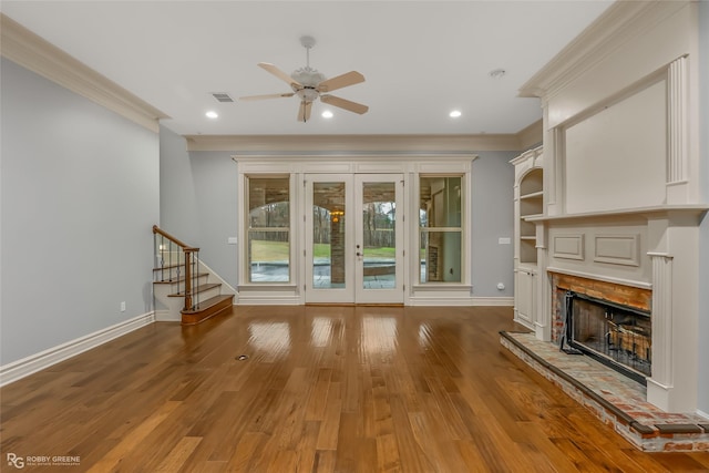 unfurnished living room with ornamental molding, hardwood / wood-style floors, ceiling fan, and french doors