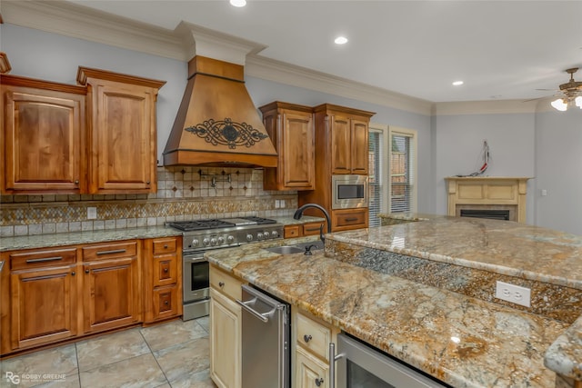 kitchen with premium range hood, sink, tasteful backsplash, appliances with stainless steel finishes, and light stone countertops