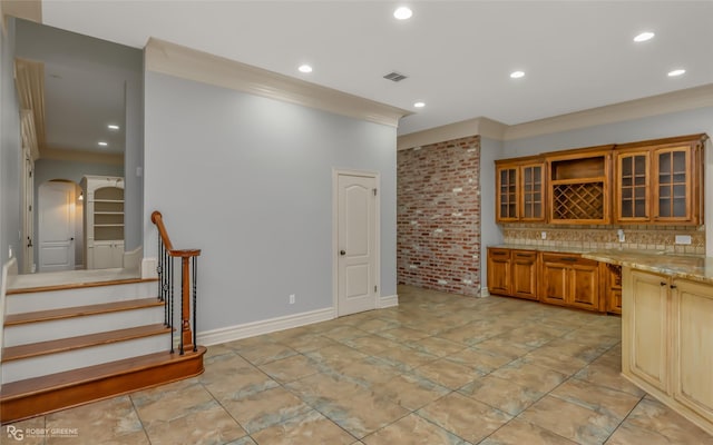 kitchen featuring light stone counters, ornamental molding, and backsplash