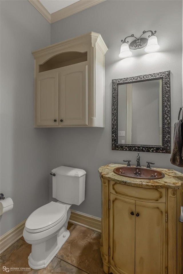 bathroom with ornamental molding, vanity, and toilet