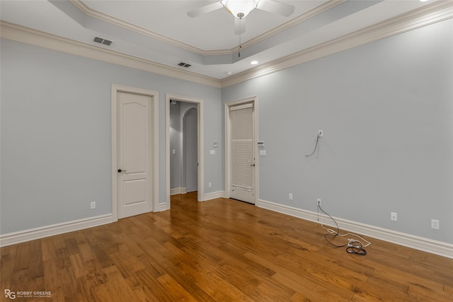 spare room with ornamental molding, hardwood / wood-style floors, ceiling fan, and a tray ceiling