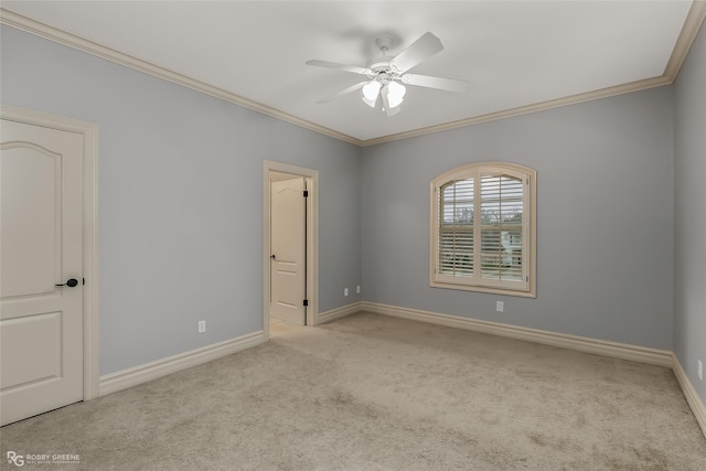 carpeted spare room featuring ceiling fan and ornamental molding