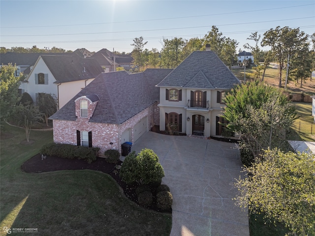 french country home with a front yard and a balcony