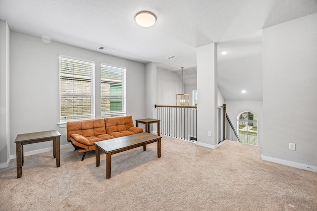 carpeted living room featuring a wealth of natural light, a chandelier, and lofted ceiling