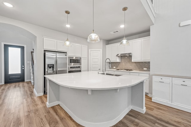 kitchen featuring white cabinetry, sink, light hardwood / wood-style flooring, built in appliances, and a kitchen island with sink