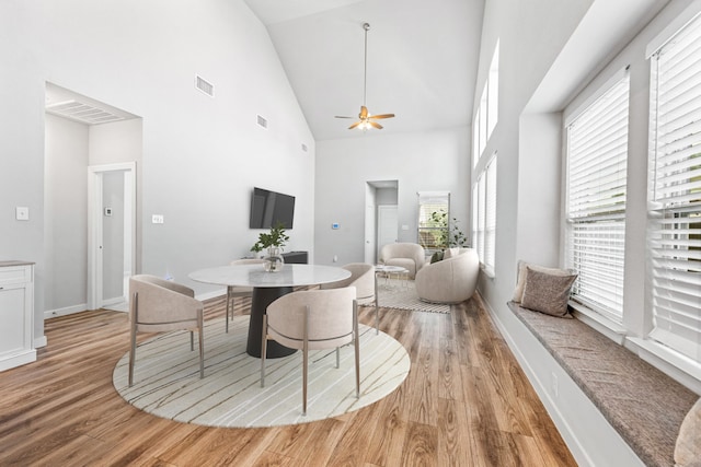 dining area featuring ceiling fan, light wood-type flooring, and high vaulted ceiling