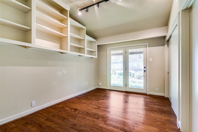 interior space with dark hardwood / wood-style floors and rail lighting