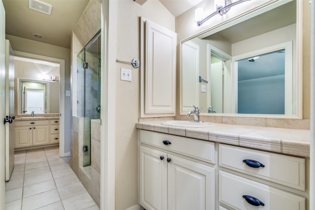 bathroom featuring vanity, tile patterned floors, and walk in shower