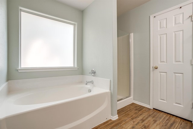 bathroom featuring shower with separate bathtub and wood-type flooring