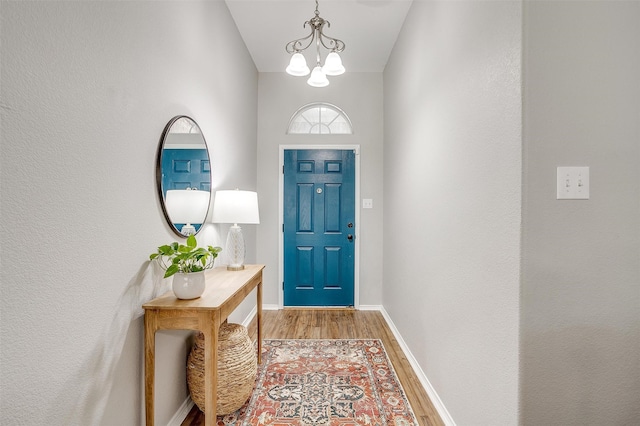 entryway with hardwood / wood-style flooring and a chandelier