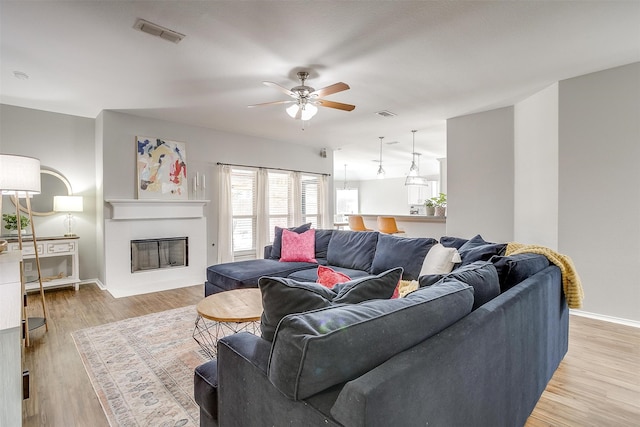 living room with light hardwood / wood-style flooring and ceiling fan