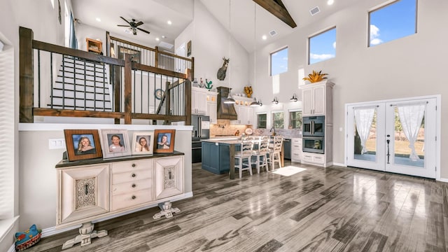 interior space with custom exhaust hood, white cabinets, a kitchen bar, and a center island