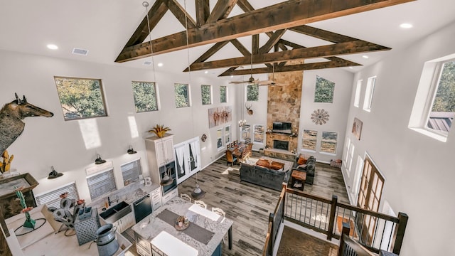 living room featuring a healthy amount of sunlight, beam ceiling, and high vaulted ceiling