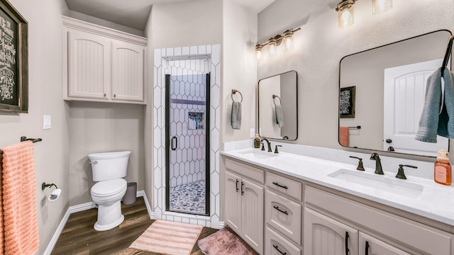 bathroom featuring toilet, hardwood / wood-style floors, a shower with door, and vanity