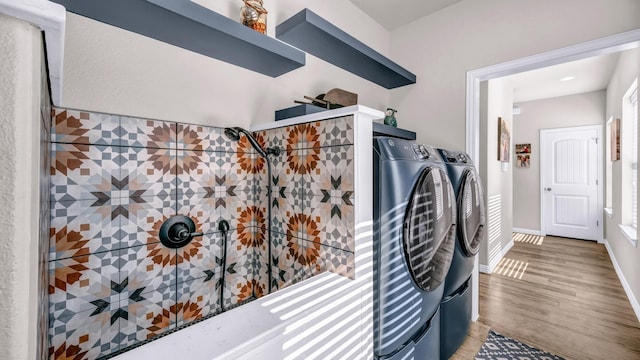 washroom with wood-type flooring and independent washer and dryer