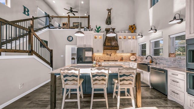 kitchen featuring dishwasher, a center island, white cabinetry, decorative backsplash, and black fridge with ice dispenser