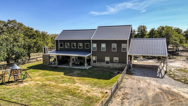 back of house with a playground and a lawn