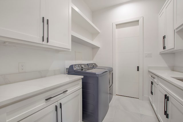 washroom with washing machine and dryer and cabinets