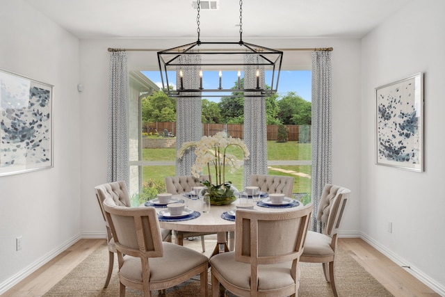 dining area featuring light hardwood / wood-style floors and an inviting chandelier