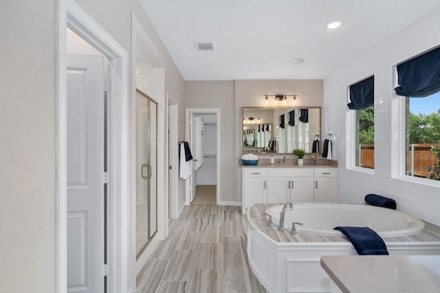 bathroom with vanity and independent shower and bath