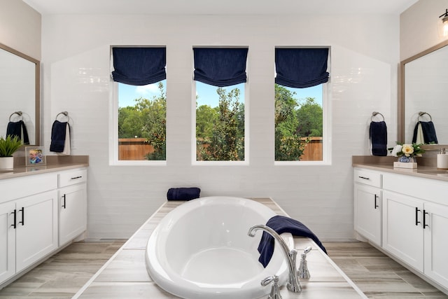 bathroom with vanity, a tub, and hardwood / wood-style floors