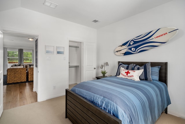 bedroom with vaulted ceiling and hardwood / wood-style flooring