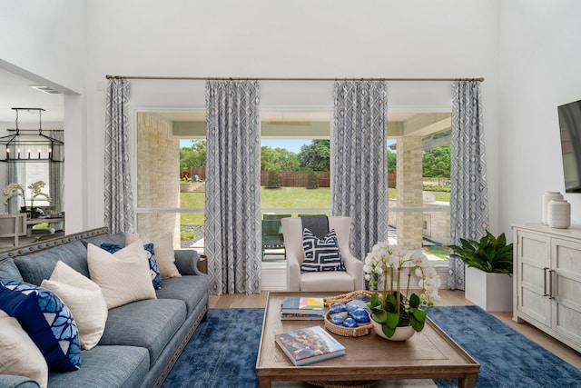 living room featuring a wealth of natural light, a chandelier, and wood-type flooring