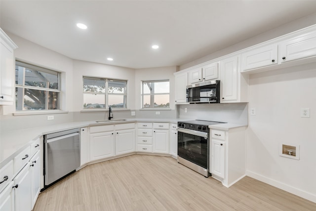 kitchen featuring appliances with stainless steel finishes, white cabinetry, and sink