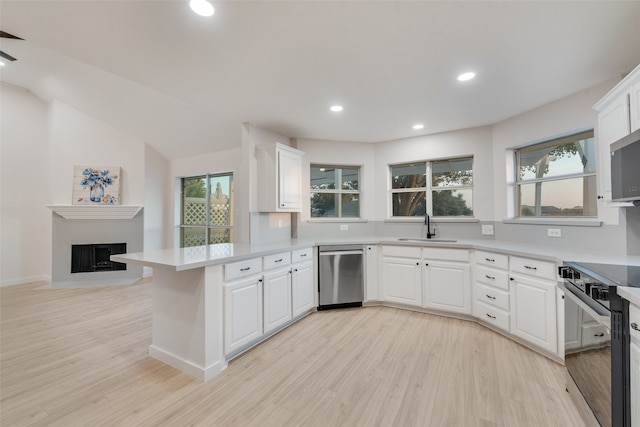 kitchen featuring appliances with stainless steel finishes, white cabinets, sink, and a wealth of natural light