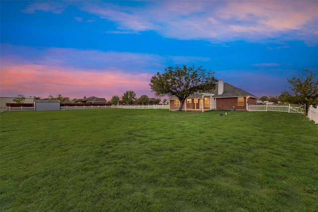 yard at dusk featuring a storage shed