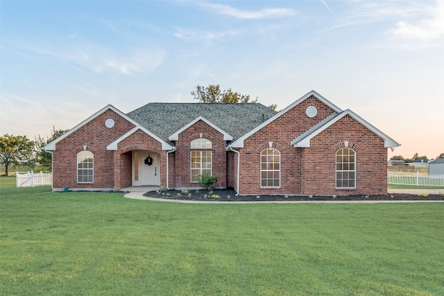 ranch-style home featuring a lawn